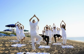 people doing yoga on beach